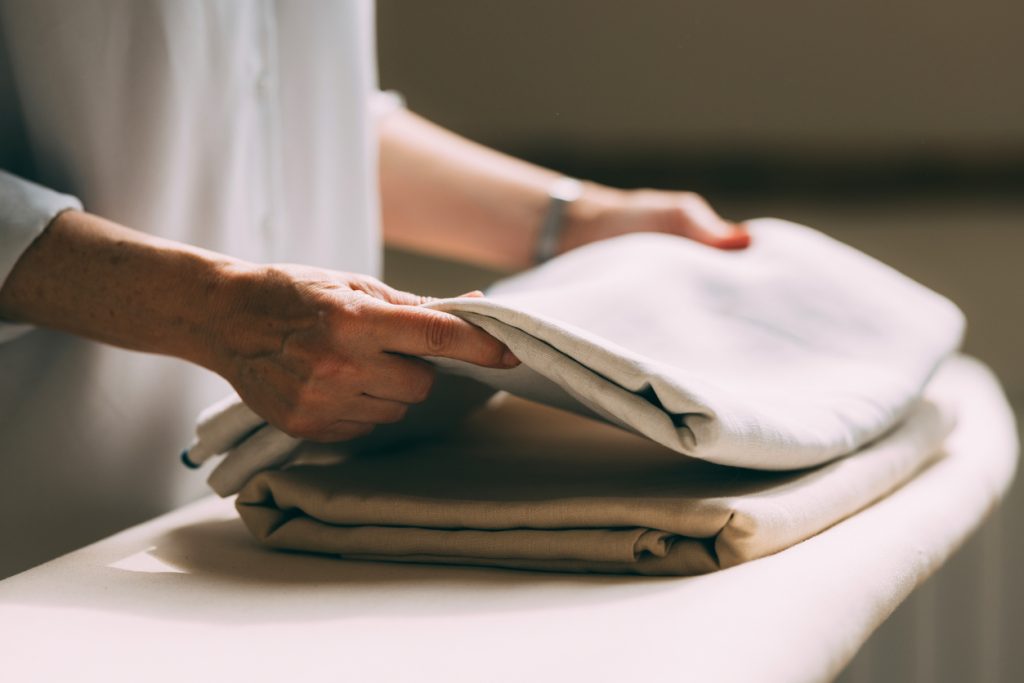 Mature Woman Folding Laundry at Home with Care