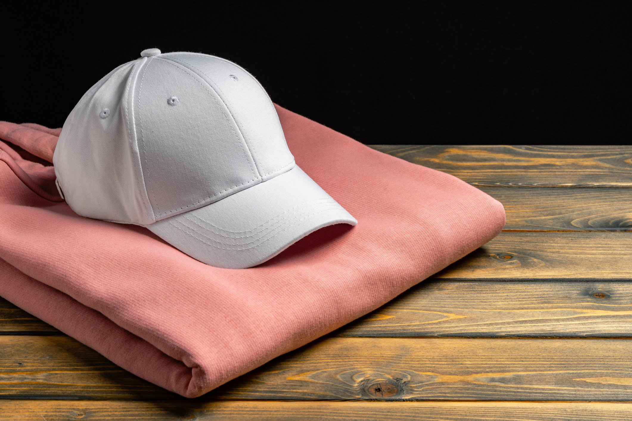 Trainers and baseball cap on wooden background
